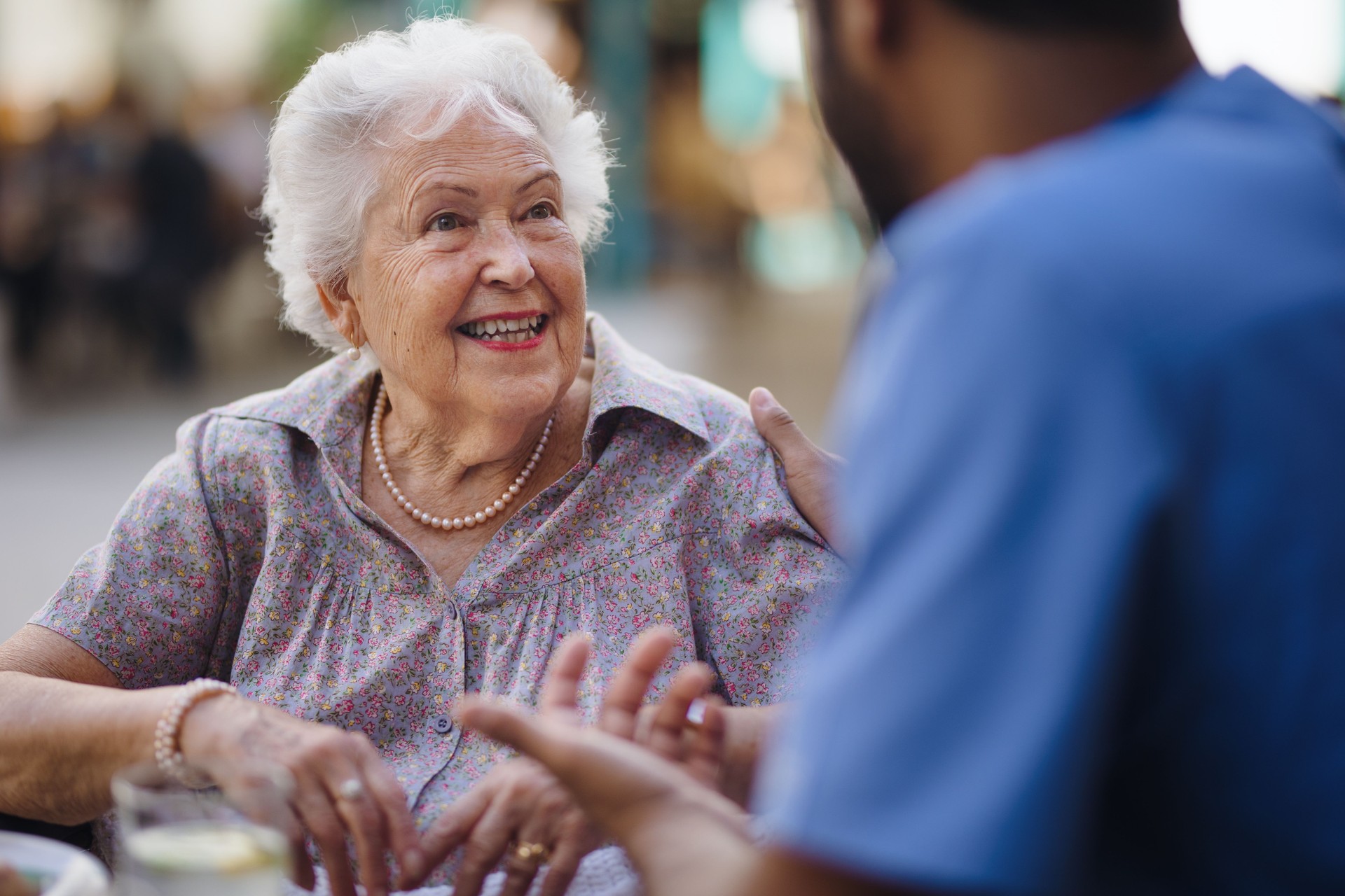 Caregiver talking with his client at cafe, having nice time together.